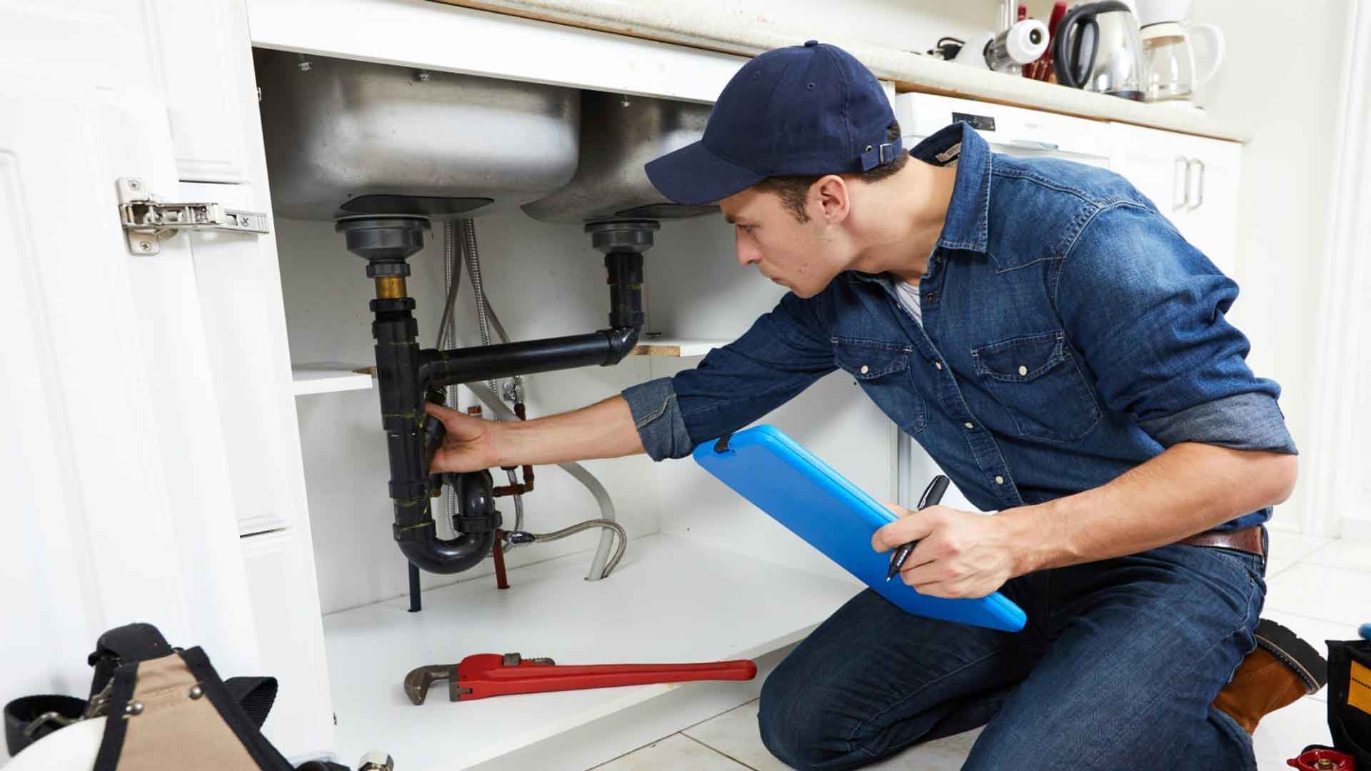 Fachmann der Terhart GmbH arbeitet sauber an der Verrohrung unter einem Waschbecken